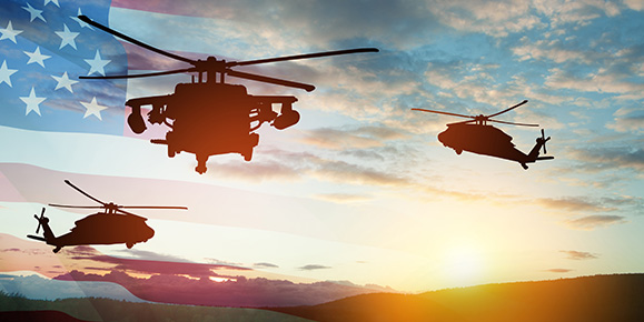 3 helicopters hovering against a sunset sky with American flag gradient in the background